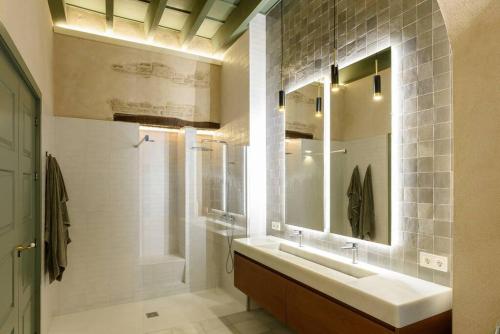a bathroom with a sink and a shower and a mirror at Luxury Palace Sevilla in Seville