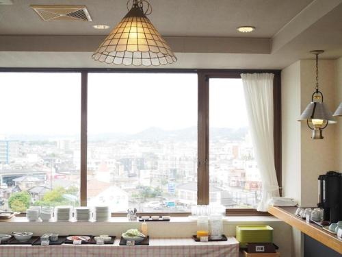 a kitchen with a large window with a view of a city at Omura Yasuda Ocean Hotel in Imazugō