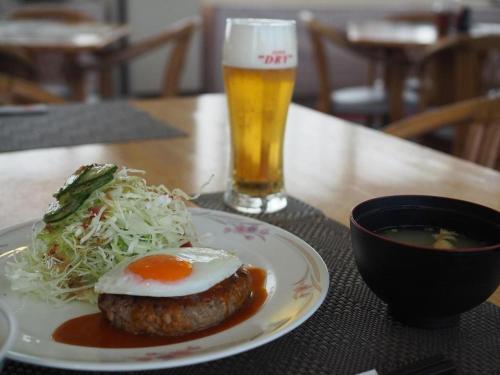 a table with a plate of food and a glass of beer at Omura Yasuda Ocean Hotel in Imazugō
