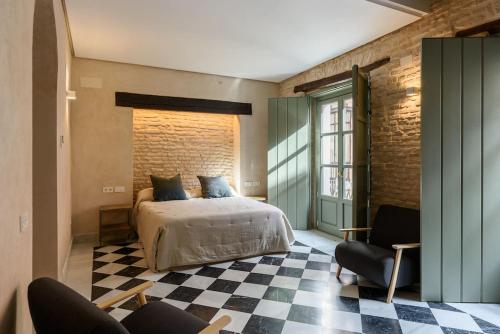 ein Schlafzimmer mit einem Bett und einem karierten Boden in der Unterkunft Luxury Palace Sevilla in Sevilla