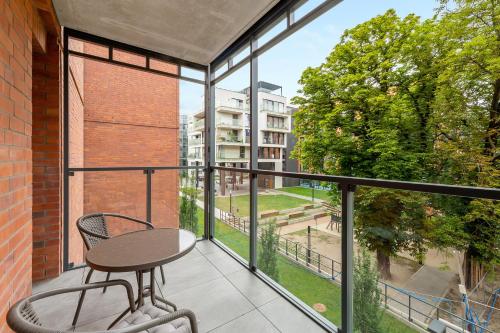 a balcony with a table and chair on a balcony at Scala Apartamenty by Moderna Profit- Łąkowa 60C in Gdańsk