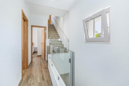 a white hallway with a staircase and a window at Casa da Avó - City Center - Topfloor 360 view apartment in Lagos