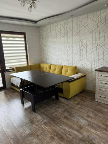 a ping pong table in a living room with a couch at Апартамент Градски Парк in Dobrich