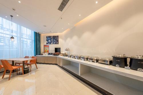 uma grande cozinha com mesa, cadeiras e balcões em City Comfort Inn Shannan Passenger Terminal em Nedong