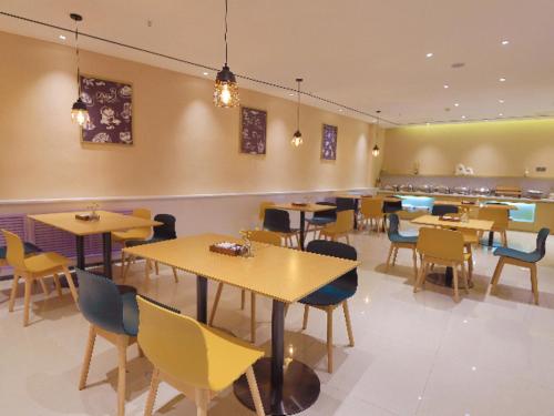 ein Restaurant mit Tischen und Stühlen in einem Zimmer in der Unterkunft City Comfort Inn Golmud City Hall Yanhu Square in Golmud