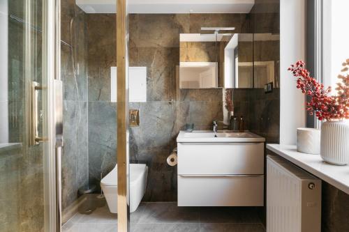 a bathroom with a toilet and a sink at ORSO Rooms & Apartments - LoftAffair Collection in Warsaw