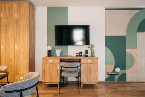 a room with a desk with chairs and a television at ORSO Rooms & Apartments - LoftAffair Collection in Warsaw
