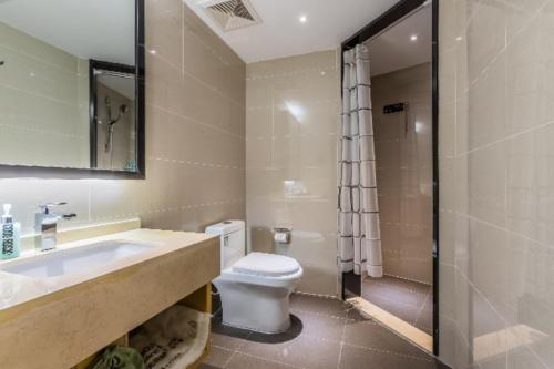 a bathroom with a toilet and a sink and a shower at City Comfort Inn Handan New Century Plaza in Sucao