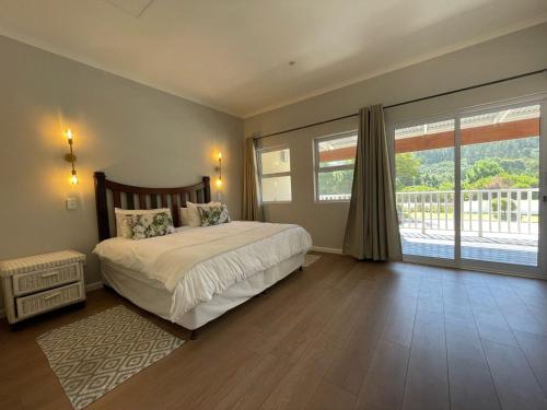 a bedroom with a bed and a large window at The Dunes Resort - Forest View in Plettenberg Bay
