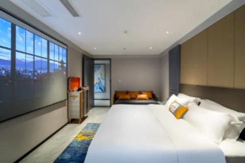 Habitación grande con 2 camas y ventana grande. en Premier City Comfort Hotel Suizhou Wuyue Plaza, en Suizhou