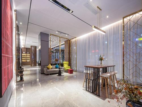 a lobby with a table and chairs in a building at Borrman Hotel Wuzhou Teng County in Tengcheng