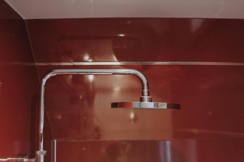 a bathroom sink with a faucet on a red wall at One Bedroom Apartment - Carbost - Skye in Carbost
