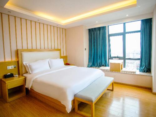 sypialnia z dużym białym łóżkiem i dużym oknem w obiekcie Borrman Hotel Yichun Municipal Government Ronghuicheng w mieście Yichun