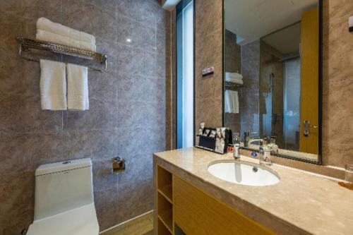 y baño con lavabo y espejo. en Borrman Hotel Yichun Municipal Government Ronghuicheng, en Yichun