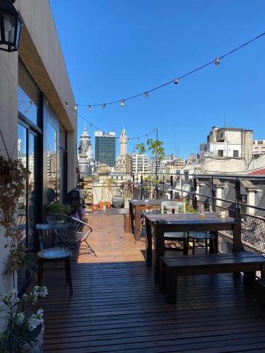 a patio with tables and benches on top of a building at Parla Hostel in Buenos Aires