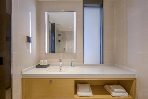 a bathroom with a sink and a mirror at City Comfort Inn Beihai Qiaogang Window of the Sea in Dianbailiao