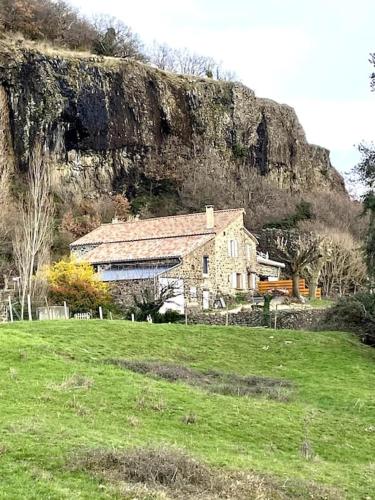 une maison dans un champ en face d'une montagne dans l'établissement La ferme de mon grand-pėre, Gîte les Bourriaux 6p 3ch, à Saint-Pons