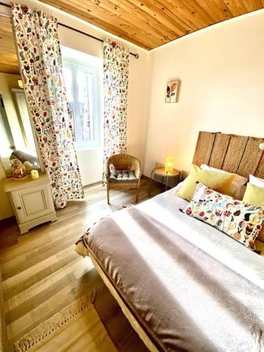 une chambre avec un grand lit et une fenêtre dans l'établissement La ferme de mon grand-pėre, Gîte les Bourriaux 6p 3ch, à Saint-Pons