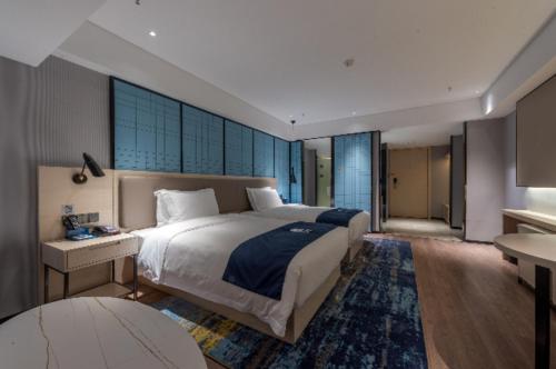een slaapkamer met een groot bed en een groot raam bij Echarm Hotel Wuhu Pedestrian Street High-speed Railway Station in Wuhu