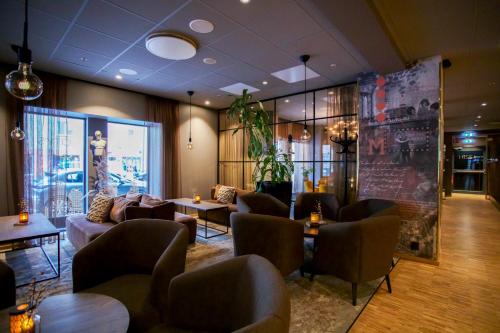 a lobby with couches and tables in a restaurant at Scandic Karlstad City in Karlstad