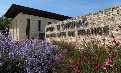 a brick building with flowers in front of it at La Plume in Orgnac-lʼAven