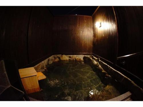 a bath tub with a bench in the middle of a room at Hotel Miyoshino Annex in Sano