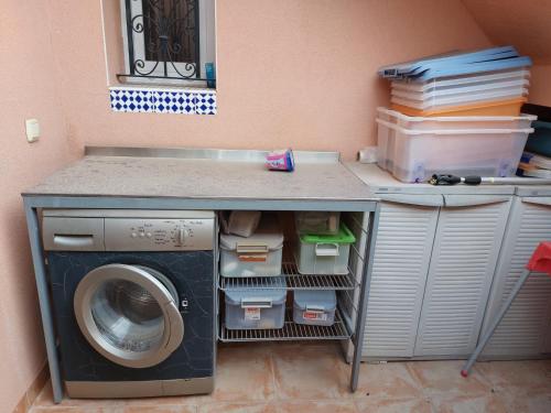 a laundry room with a washing machine under a counter at Villa Christophe in Alicante