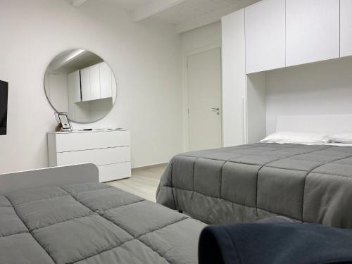 a white bedroom with a bed and a mirror at Lux House in Naples