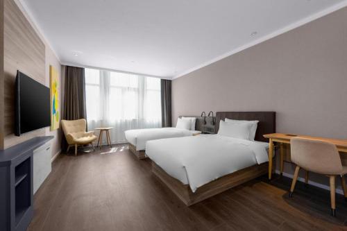 Hanting Hotel Longnan Cheng County Panxuan Road tesisinde bir odada yatak veya yataklar