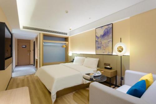 Starway Hotel Nanchang Honggutan Lvdi Twin Tower Wanda Plaza tesisinde bir odada yatak veya yataklar