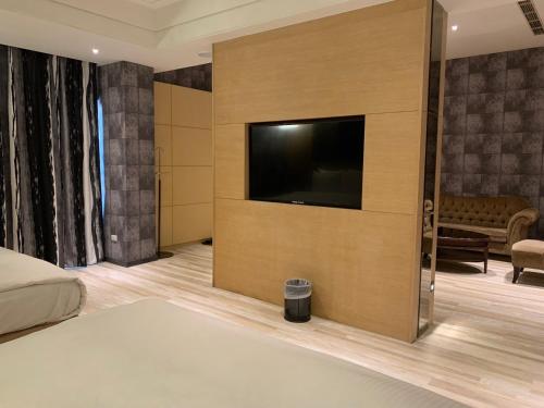 a bedroom with a flat screen tv on a wall at Aquarius Motel in Taichung