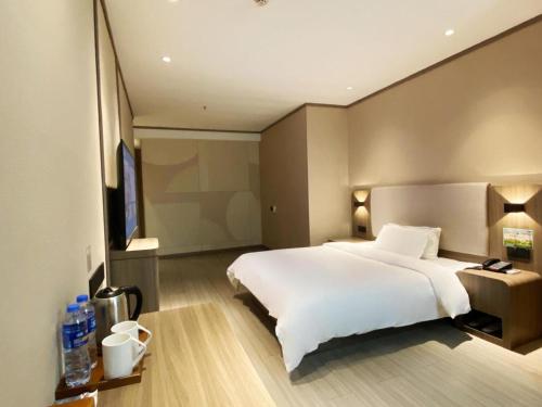 سرير أو أسرّة في غرفة في Hanting Hotel Wenling Daxi