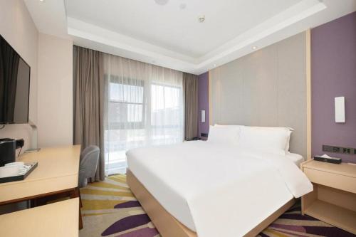 een hotelkamer met een groot wit bed en een raam bij Starway Hotel Nanjing Jiaoyuan Metro Station in Jiexi