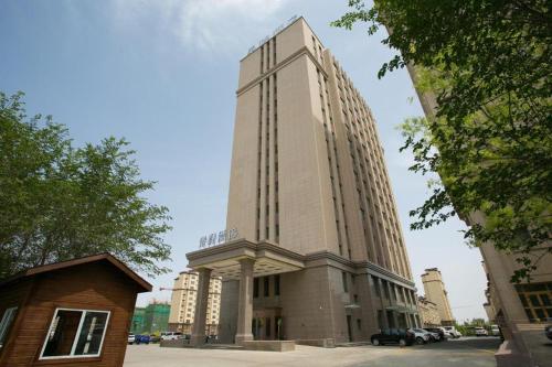 un grande edificio alto in una città di Starway Hotel Changji Qitai Bus Station a Xibeiwan