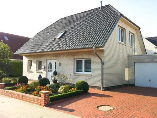 a white house with a gray roof and a brick driveway at Schönes Zimmer am Jans Kamp 3 mit Küche Self-Check-In in Vechta