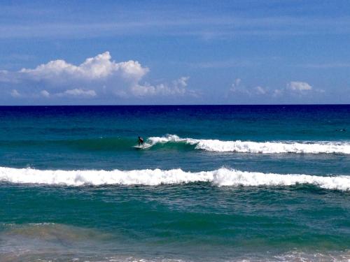 a person riding a wave on a surfboard in the ocean at Royal Residence Apartment Condos in Cabarete