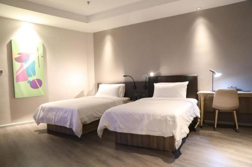 Säng eller sängar i ett rum på Hanting Premium Hotel Turpan Cathay Pacific Minsheng Square