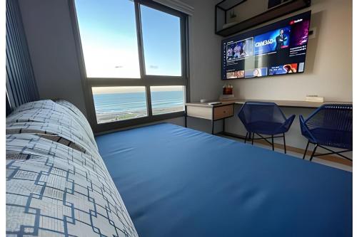 a bedroom with a bed and a flat screen tv at New Studios - O paraíso é aqui in Salvador
