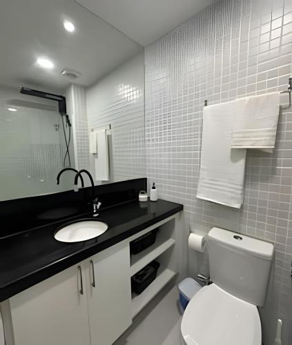 a bathroom with a white toilet and a sink at New Studios by VLV Stays in Salvador