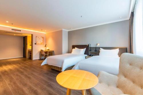 Un ou plusieurs lits dans un hébergement de l'établissement Hanting Premium Hotel Tianjin Nankai University