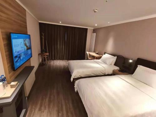 Gulta vai gultas numurā naktsmītnē Hanting Premium Hotel Gonghe Qinghai Lake South Street