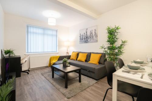 a living room with a couch and a table at 2 Bedroom Apartment-Free Parking in Wishaw