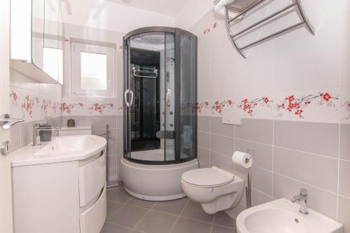 a white bathroom with a toilet and a sink at Apartment Nonna Laura in Portorož
