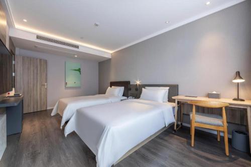 Łóżko lub łóżka w pokoju w obiekcie Hanting Premium Hotel Quzhuo Nanhu Plaza