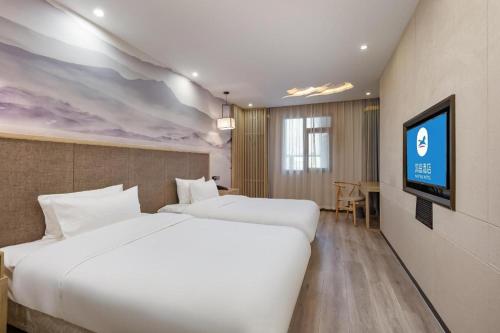 Giường trong phòng chung tại Hanting Hotel Nanjing Mochou Lake Huju South Road