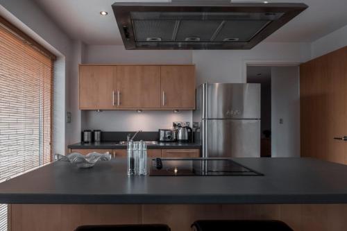 a kitchen with a refrigerator and a black counter top at The Chambers, Riverside West in Leeds