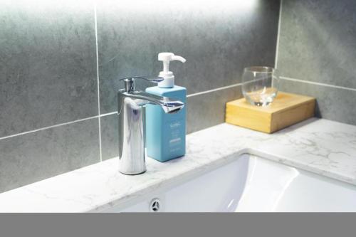 un lavandino in bagno con una bottiglia di sapone e un bicchiere di Starway Hotel Lanzhou West Passenger Station North Square a Lanzhou