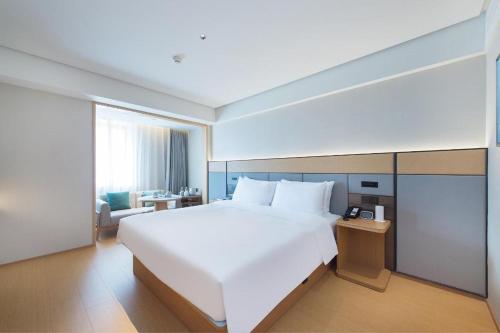 Tempat tidur dalam kamar di JI Hotel Dalian Qingniwa Commercial Street
