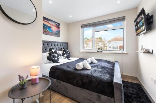 a bedroom with a large bed and a table at Charming Serviced Ensuite Modern Studio - Sleeps 2 - Near Wembley Stadium - Good Transport Link to Central London - Harrow HA3 in Hatch End