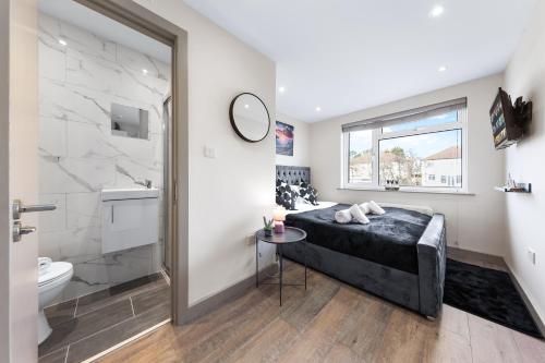 uma casa de banho com uma cama, um chuveiro e um WC. em Charming Serviced Ensuite Modern Studio - Sleeps 2 - Near Wembley Stadium - Good Transport Link to Central London - Harrow HA3 em Hatch End